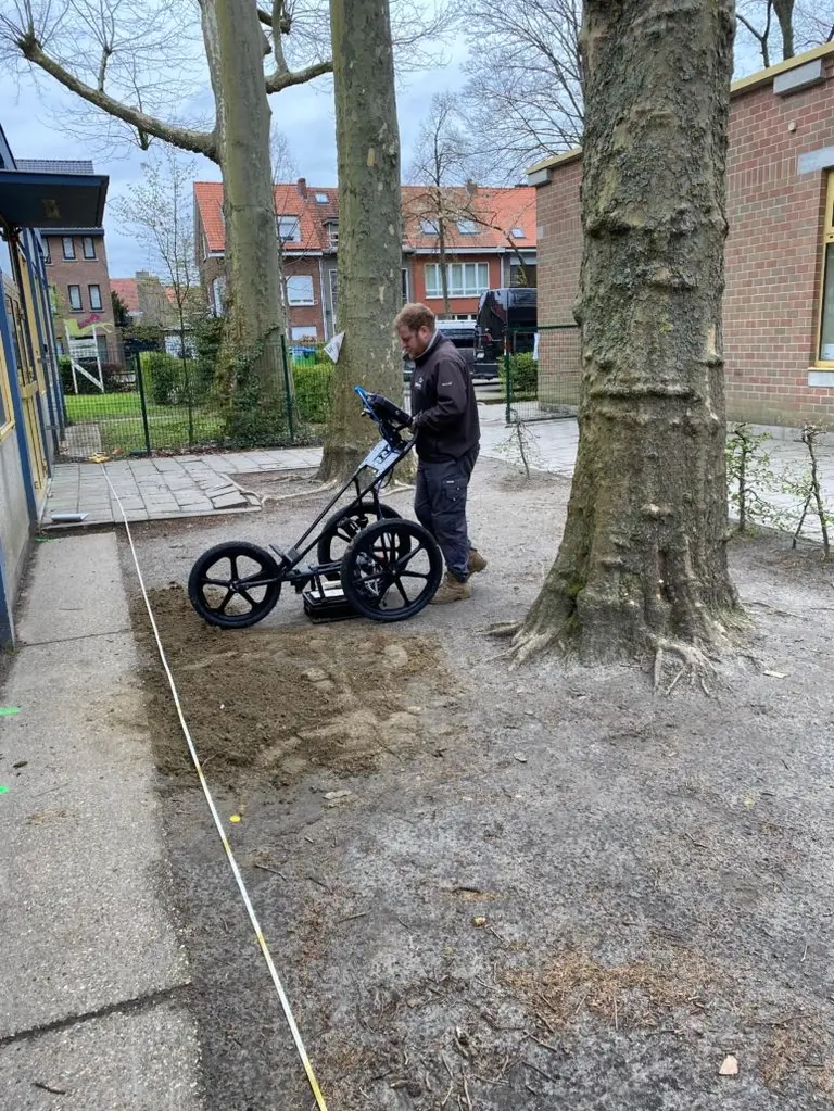 Medewerker van Beta Infra voert grondradaronderzoek uit op een schoolplein