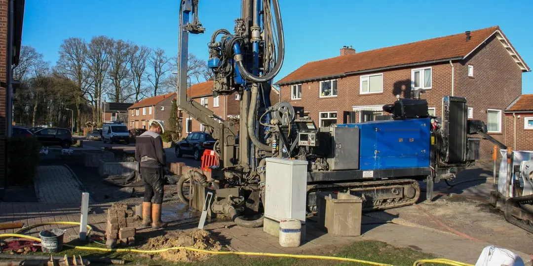 Een boorstelling voor gestuurd boren aan het werk in een woonstraat met rijtjeshuizen